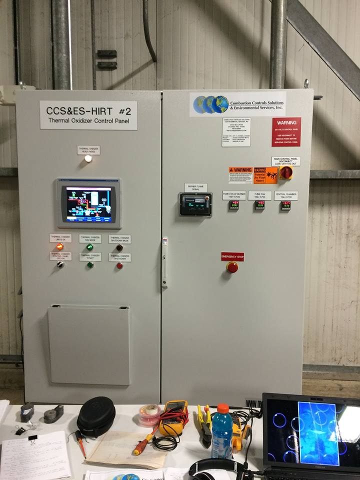 Industrial control panel with PLCs and I/O modules running SCADA software for process monitoring and control